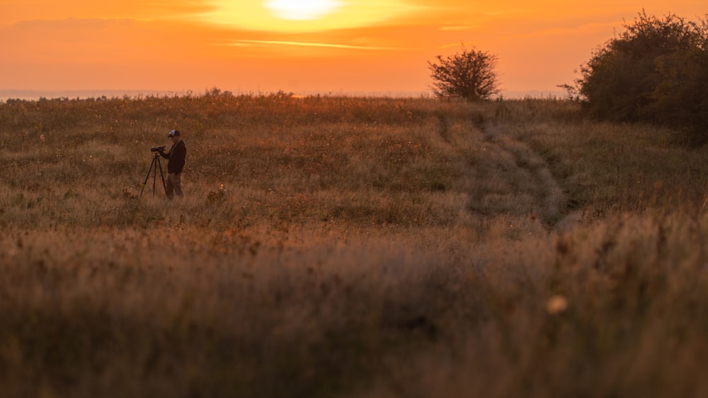 Eine Person, die bei Sonnenuntergang auf einem Feld steht