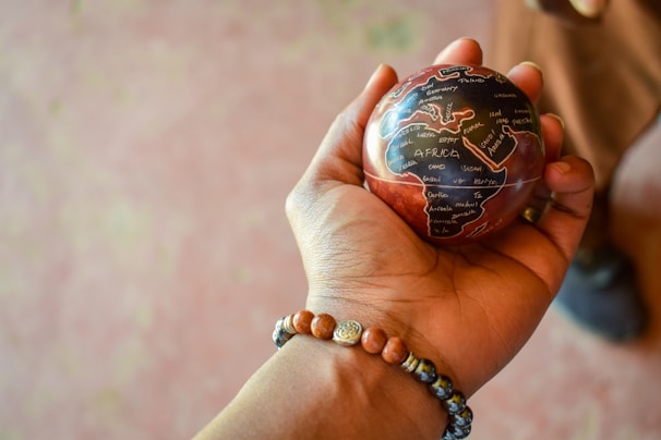 a person holding a small globe in their hand