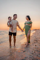 A warm, cinematic shot of a family sharing a quiet moment on a soft sand beach at golden hour.