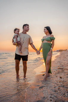 An authentic moment of a family playing on a sandy beach under warm, glowing sunlight