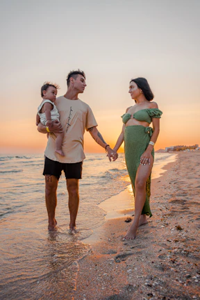 Warm, sun-drenched image of a family embracing on a sandy beach.