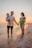 A happy family standing on the sandy shores of Portugal's Silver Coast at sunset.
