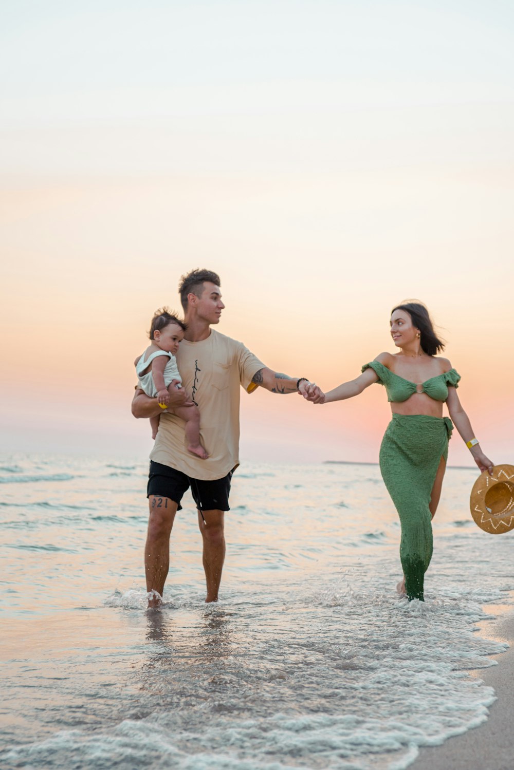 a man and woman holding hands while walking on the beach