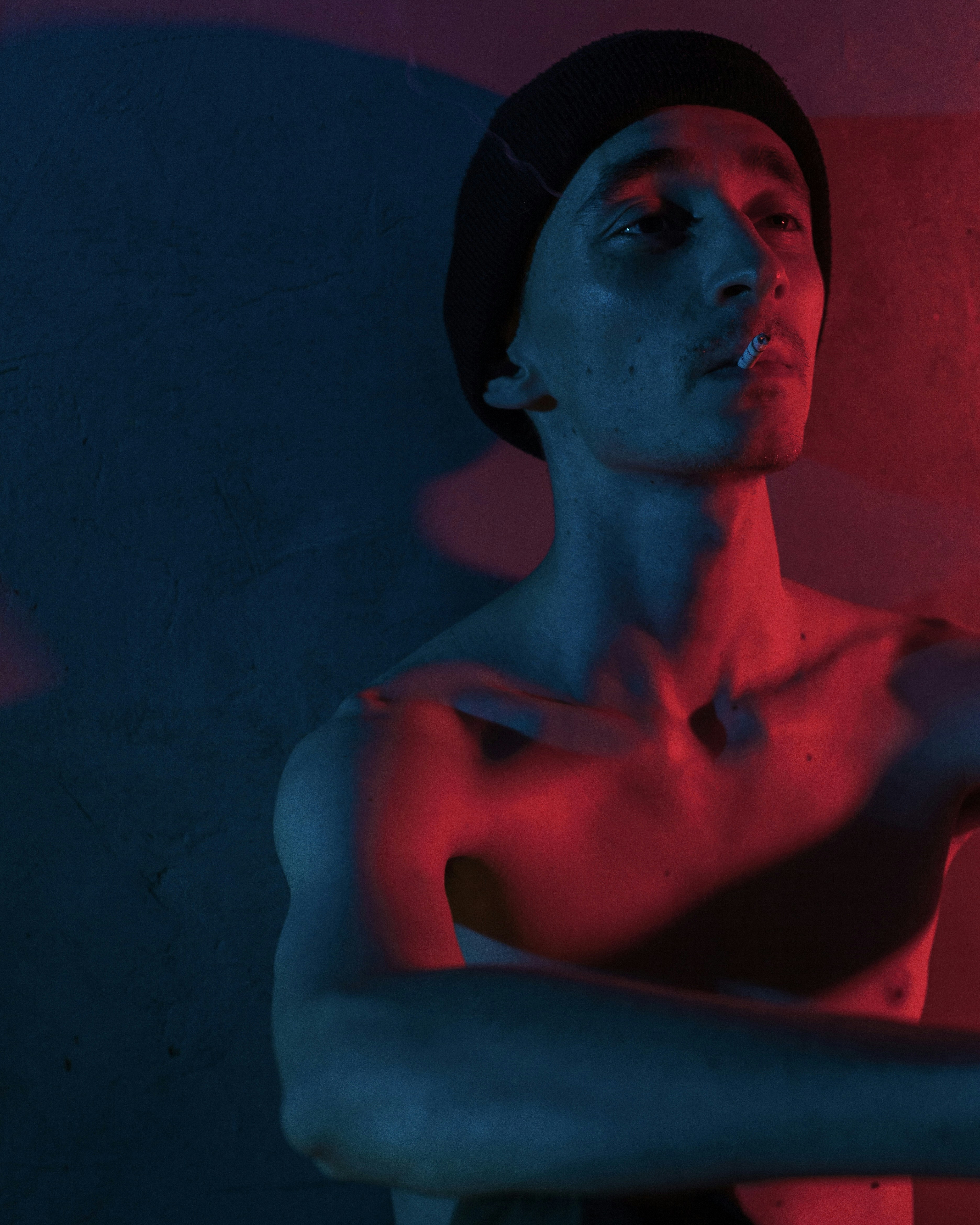 a man with his arms crossed in front of a red light