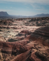 a view of a rocky landscape with mountains in the background