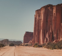 a group of people riding horses down a dirt road