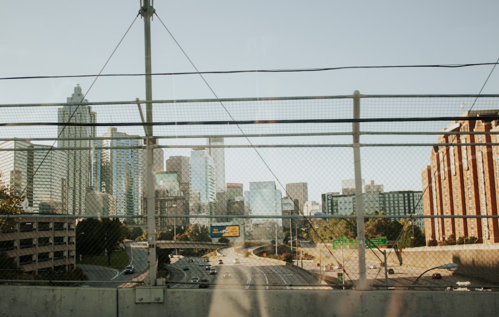 a view of a city from behind a fence