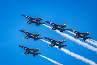 a group of fighter jets flying through a blue sky