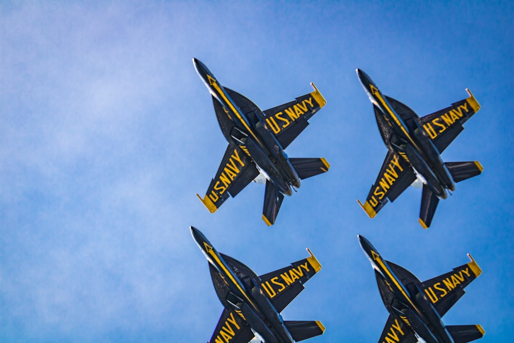 a group of fighter jets flying through a blue sky