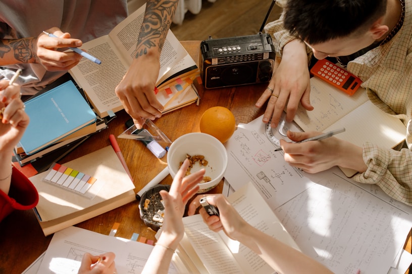 A diverse group of editors and reviewers collaborating over academic manuscripts, surrounded by scholarly books and notes.