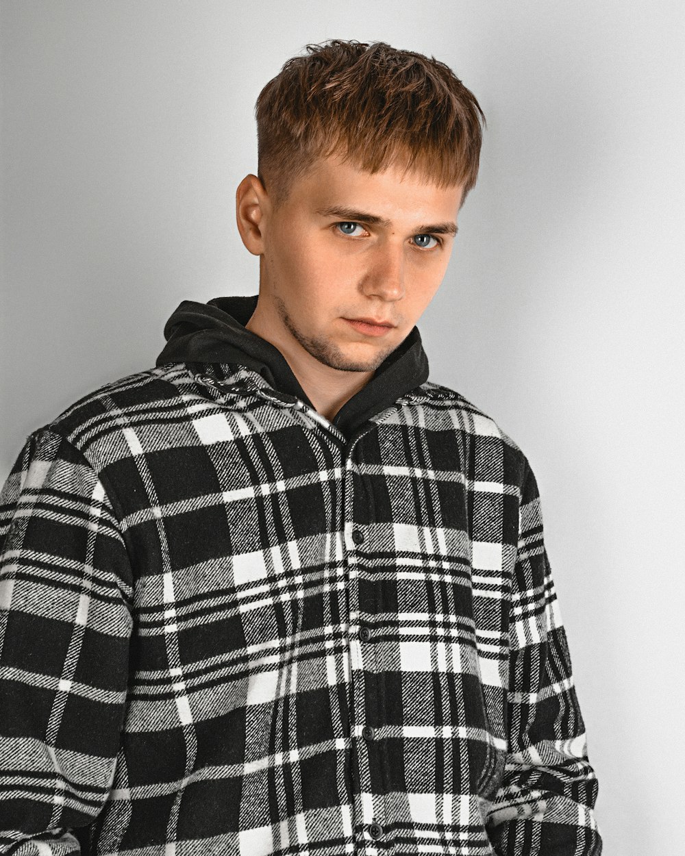 a young man wearing a black and white checkered jacket