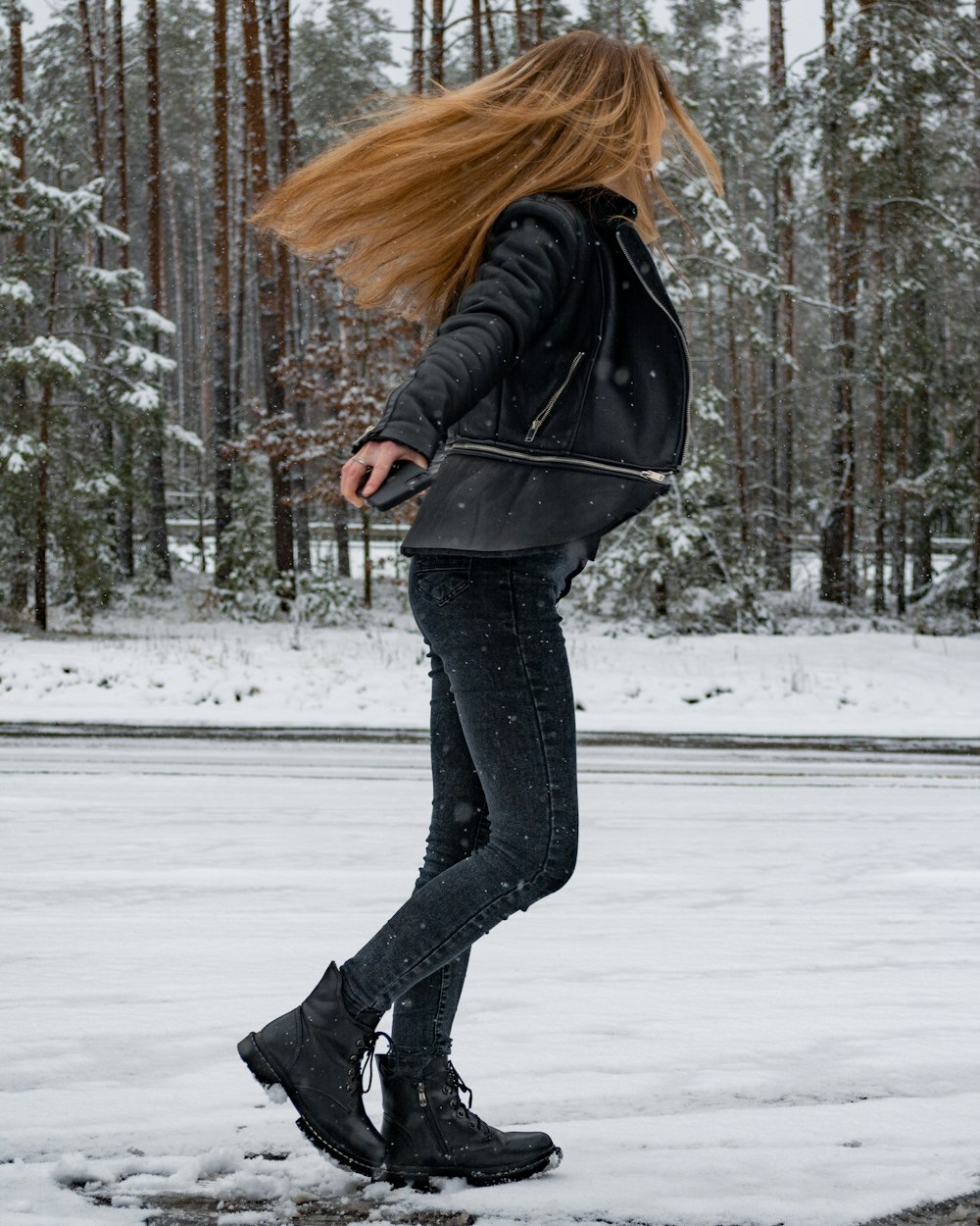 a woman with long hair walking in the snow