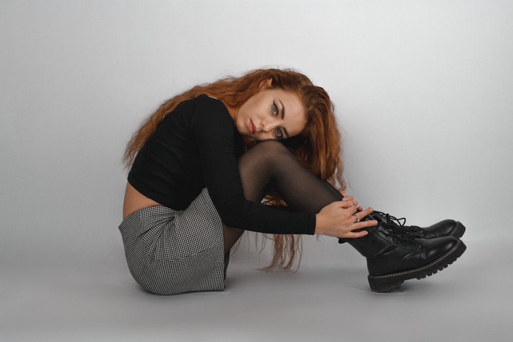 a woman with red hair and black shoes