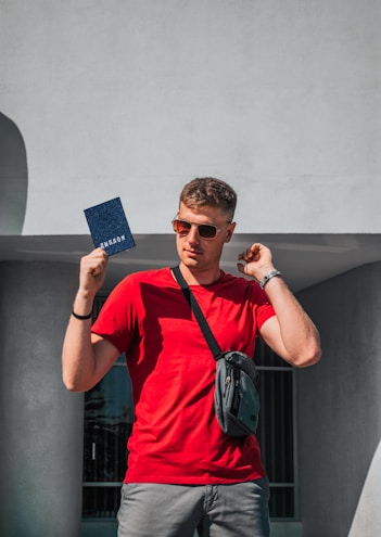 a man in a red shirt holding a blue card