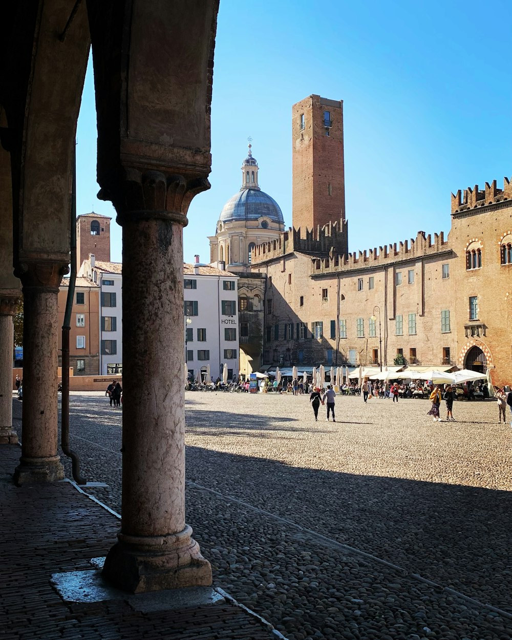 Un gruppo di persone che camminano lungo una strada accanto a edifici alti