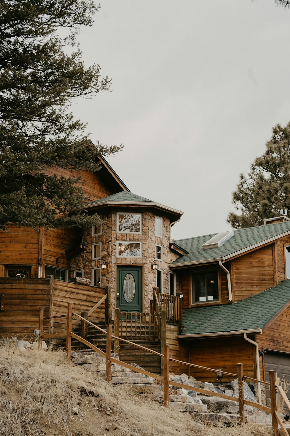 a wooden house with a green door on a hill