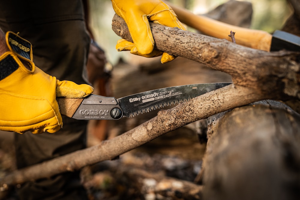 a person holding a pair of yellow gloves and a pair of scissors