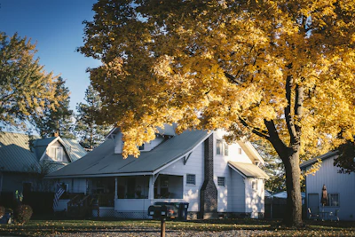 A bright, welcoming New England home with a 'Sold' sign in the front yard on a crisp autumn day.