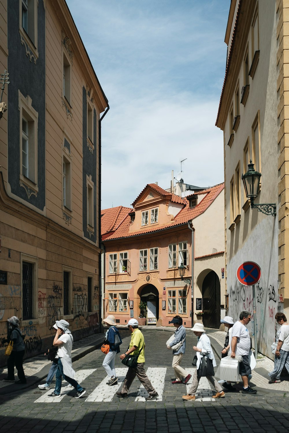 a group of people walking across a cross walk