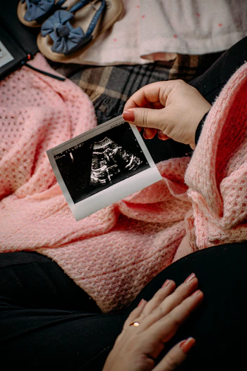 a person holding a picture of a baby in their lap