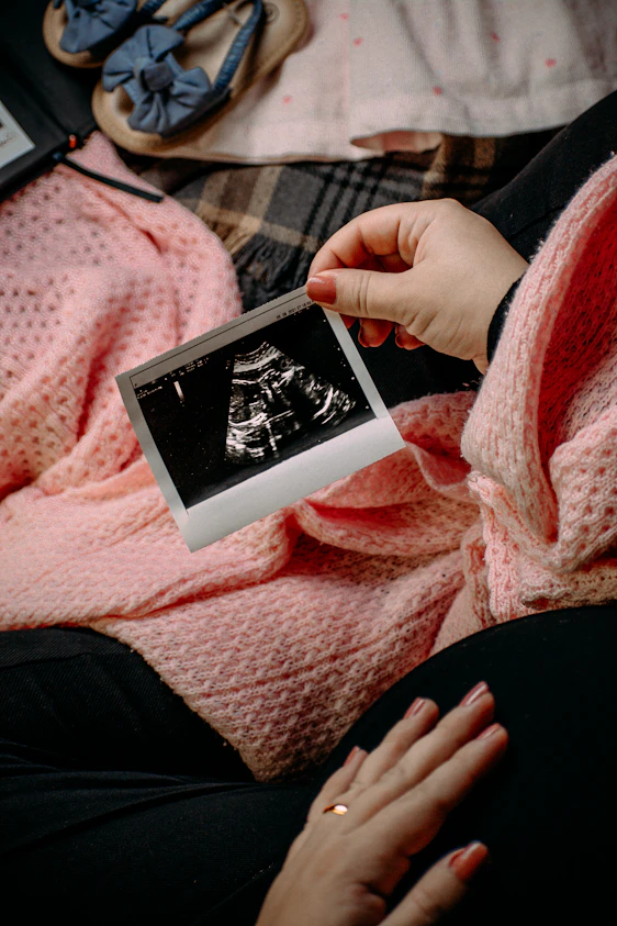 a person holding a picture of a baby in their lap