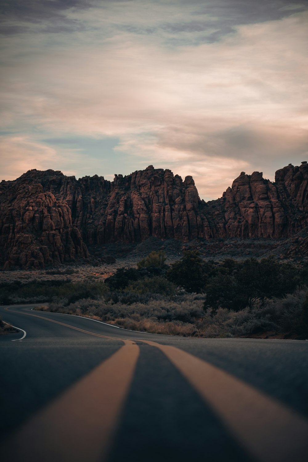 the sun is shining on the road in the desert