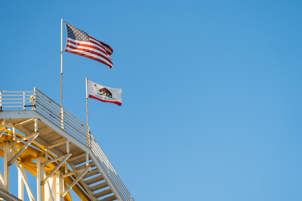 duas bandeiras americanas voando no topo de um edifício