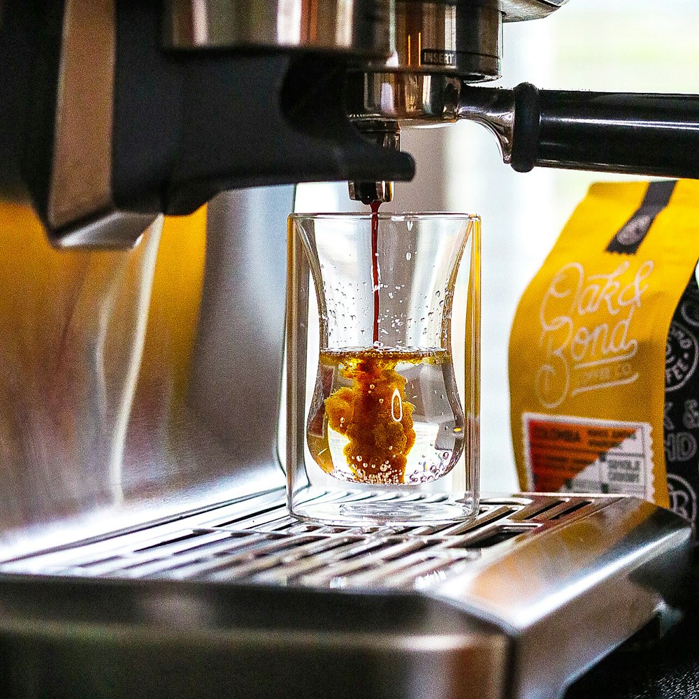 a cup of coffee being filled with liquid