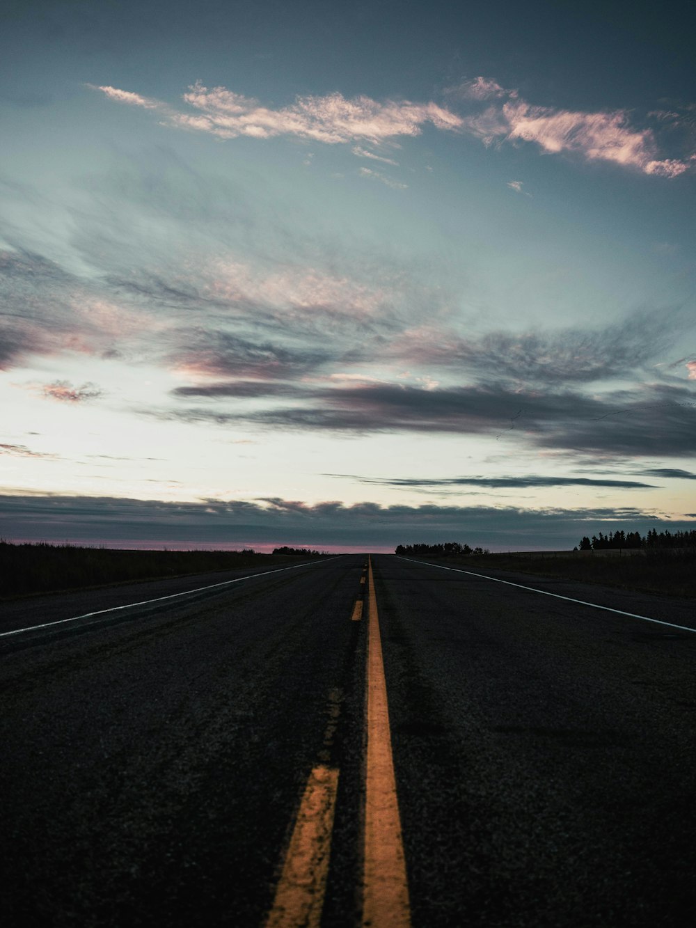 an empty road with a sky in the background