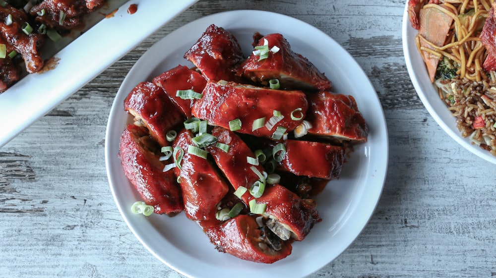 a white plate topped with meat covered in sauce