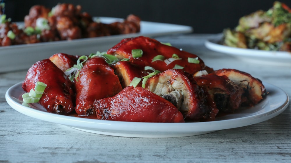 a white plate topped with meat covered in sauce