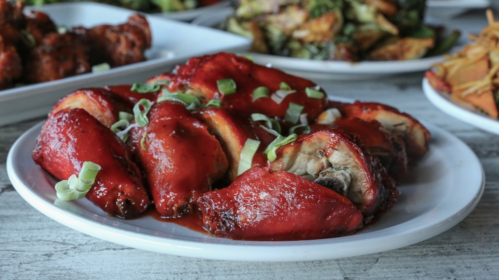 a white plate topped with meat covered in sauce