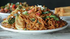 a plate of noodles with broccoli and other vegetables