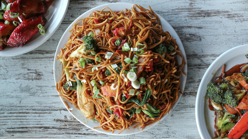 three plates of food on a wooden table