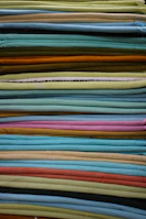 Folded stacks of colorful Bhagalpuri silk fabrics showcasing their natural sheen and texture.
