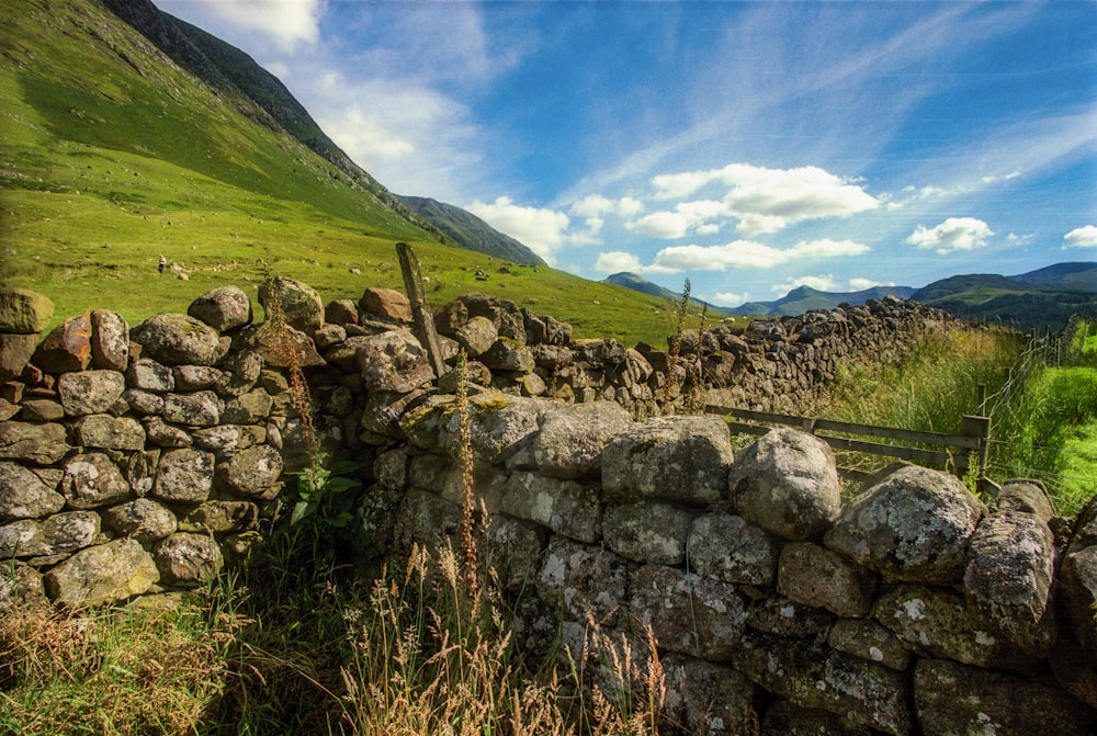 a stone wall in the middle of a field