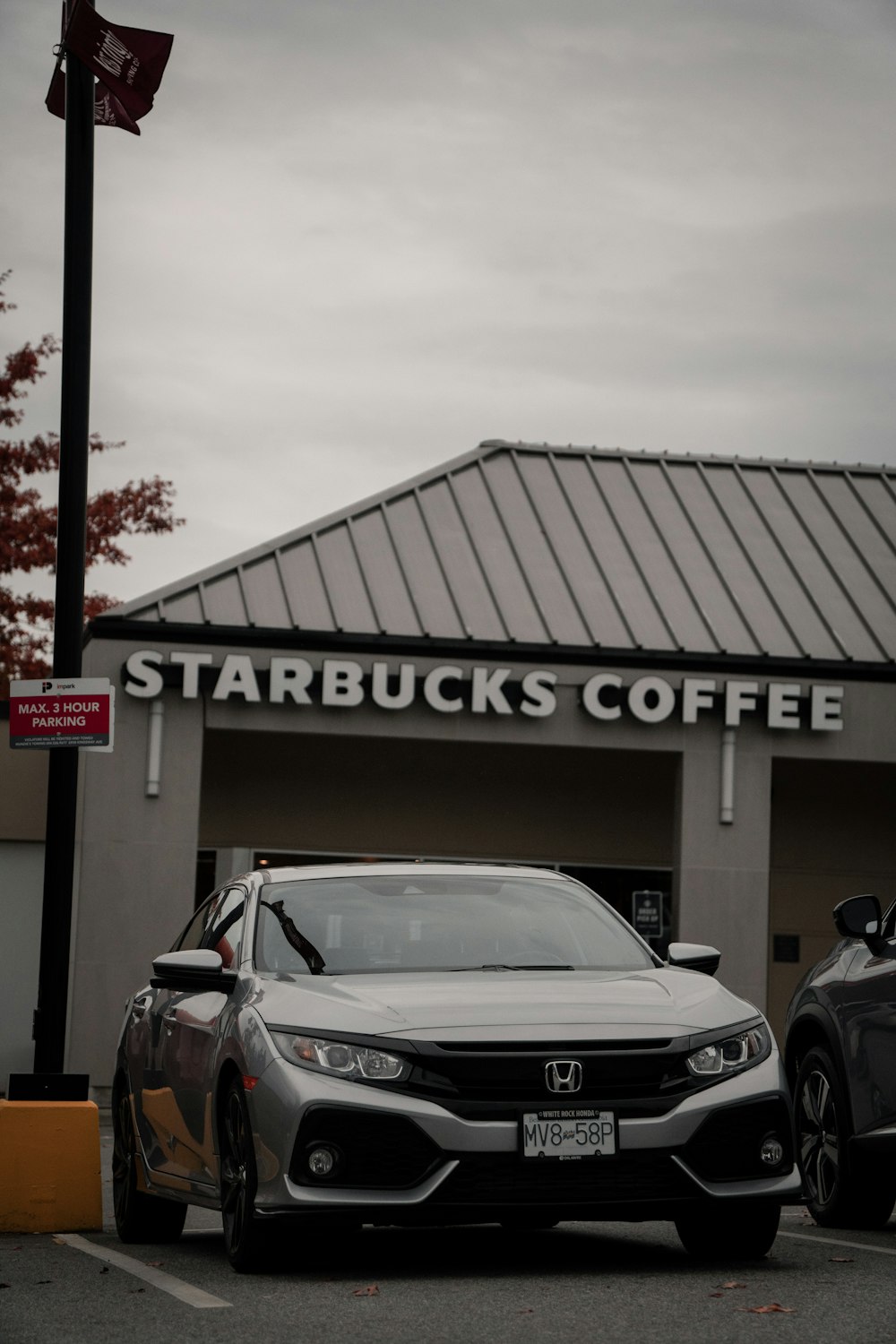 dois carros estacionados em frente a um starbucks