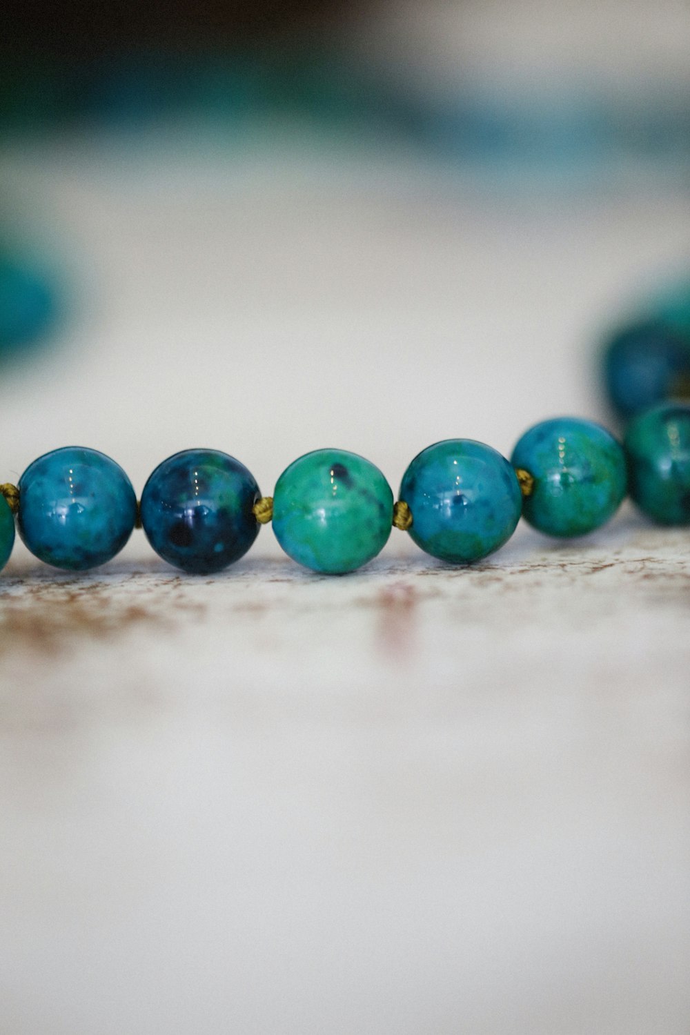 a close up of a beaded necklace on a table photo – Free Blue Image on  Unsplash