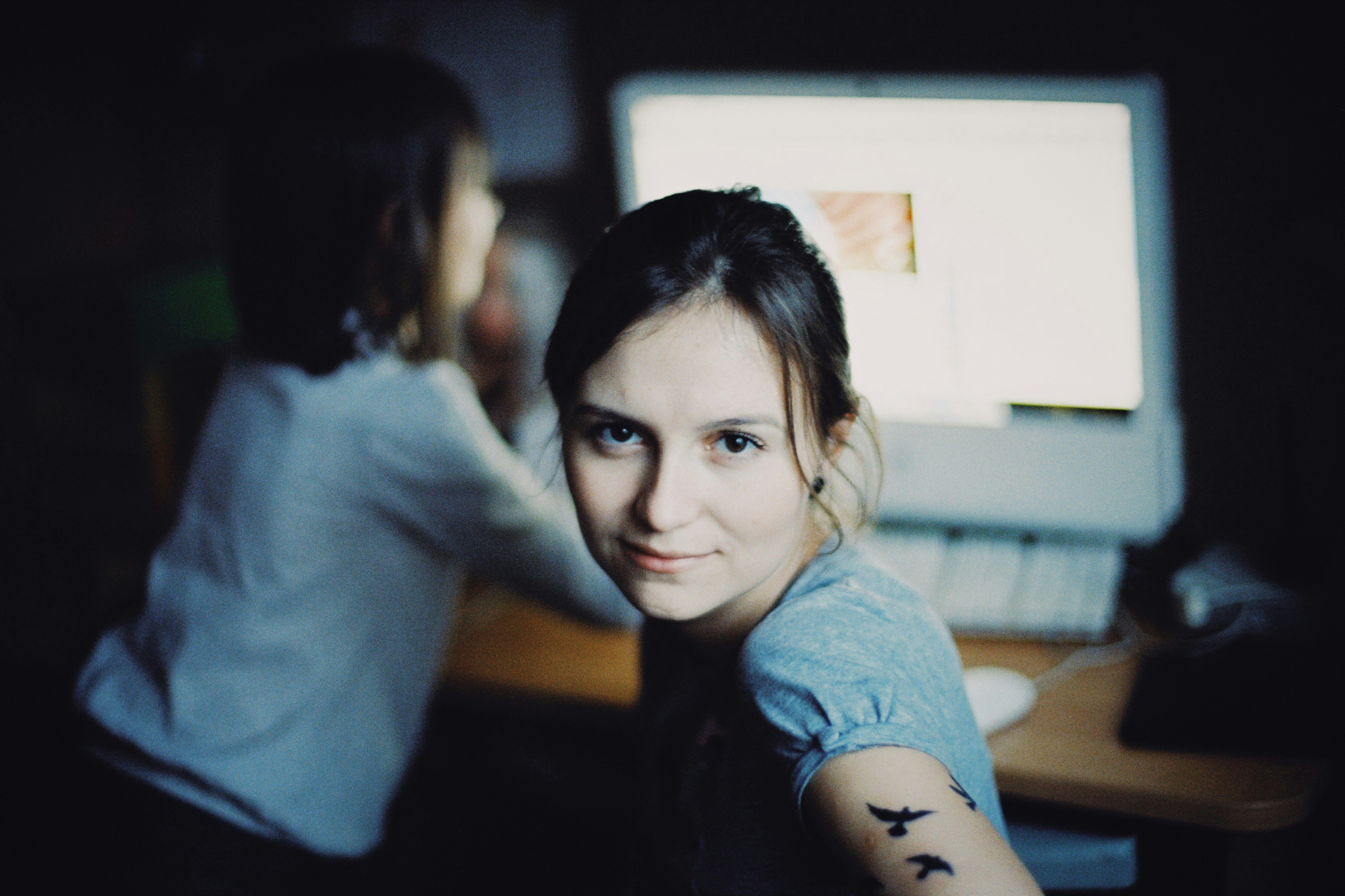 A woman with a tattoo on her arm next to a computer photo – Free ...