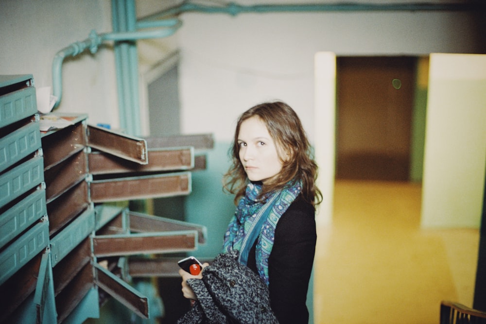 a woman standing in front of a stack of shelves