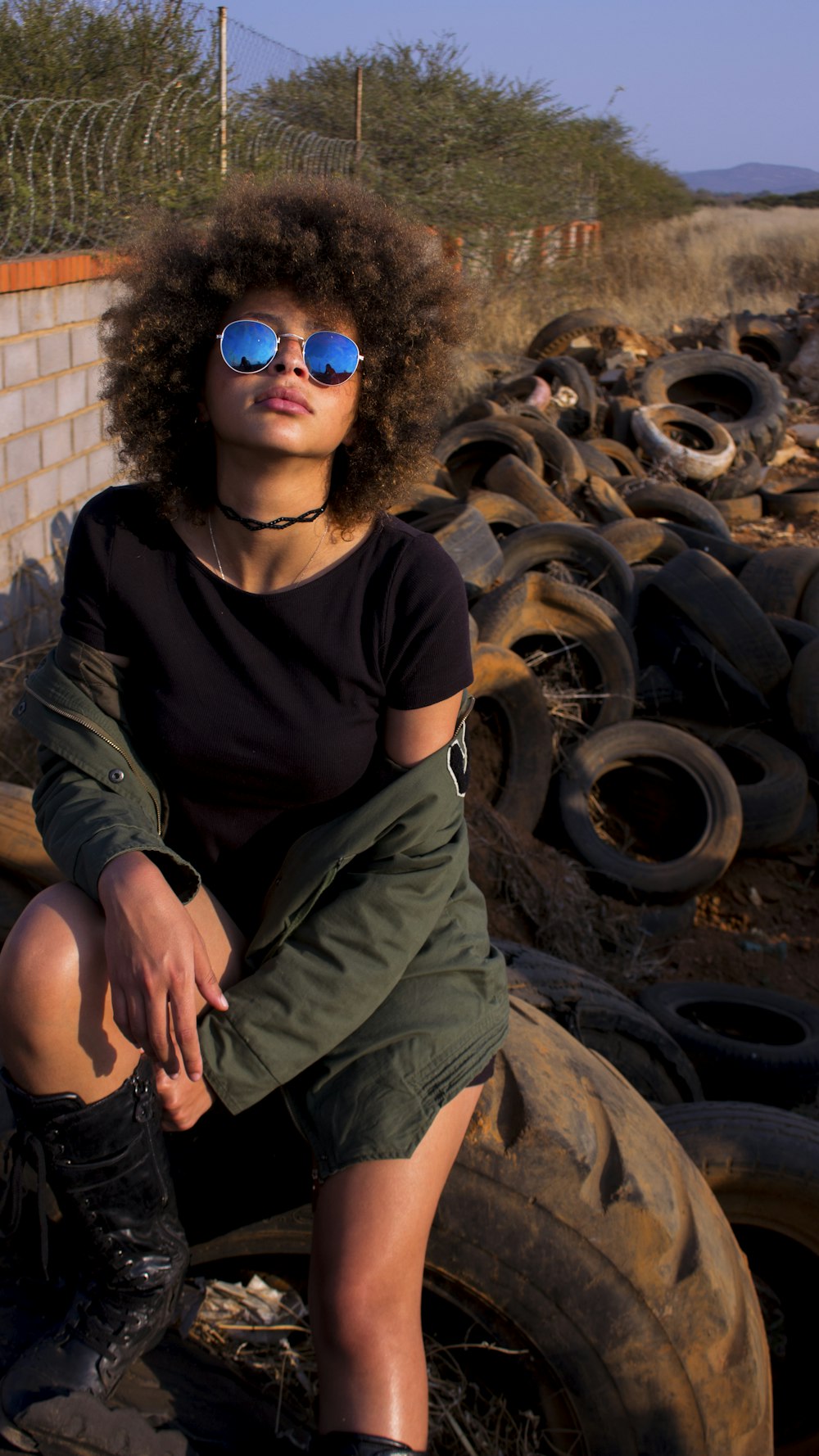 a woman sitting on top of a pile of tires