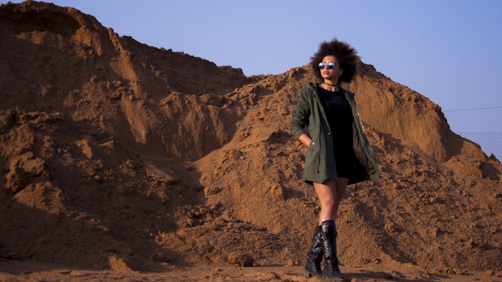 a woman standing in front of a pile of dirt