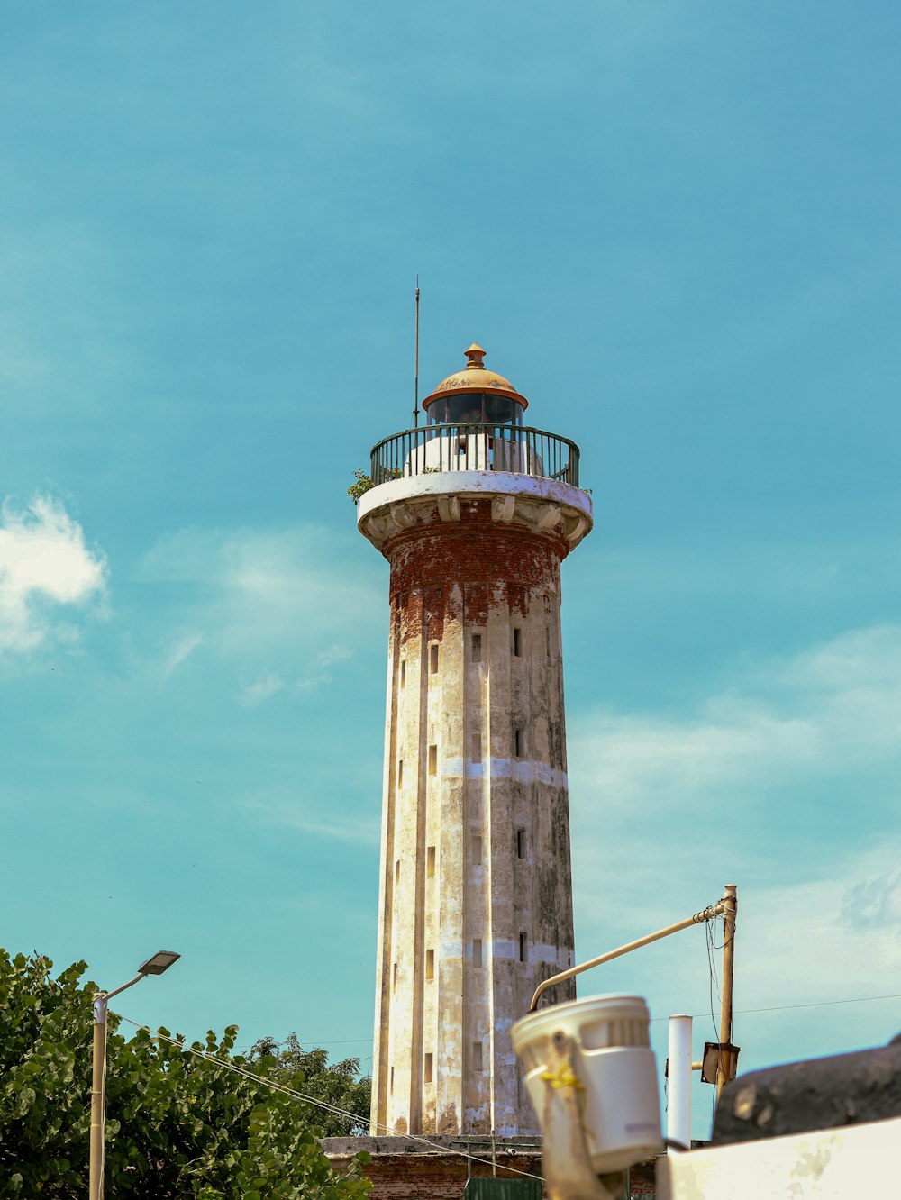 a tall light house sitting on top of a lush green field