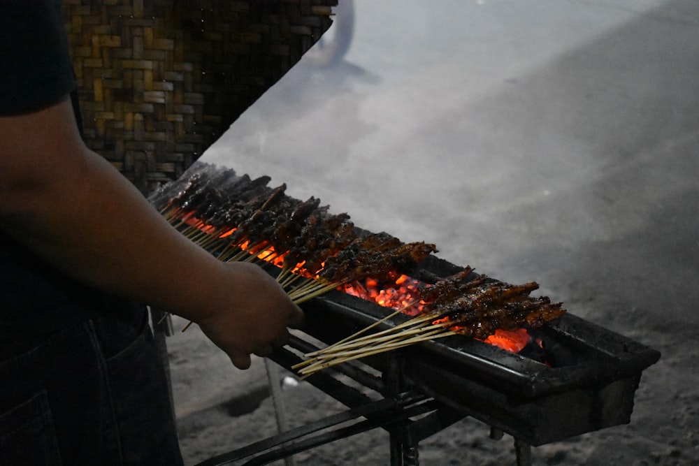 a person is cooking on a grill outside
