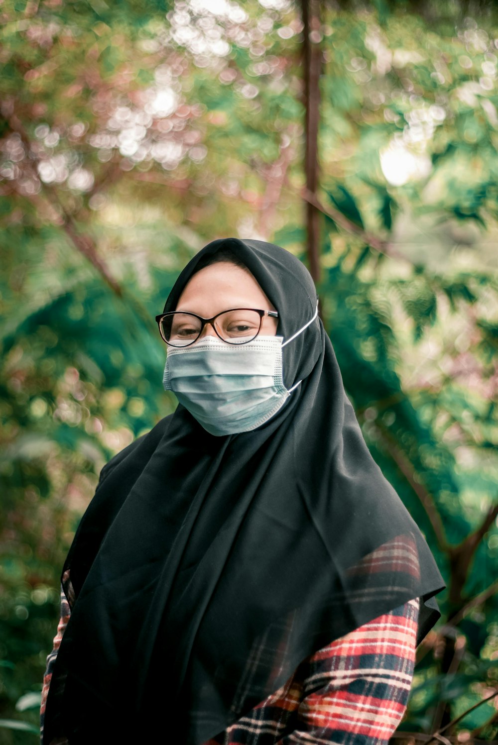 a woman wearing a face mask in the woods