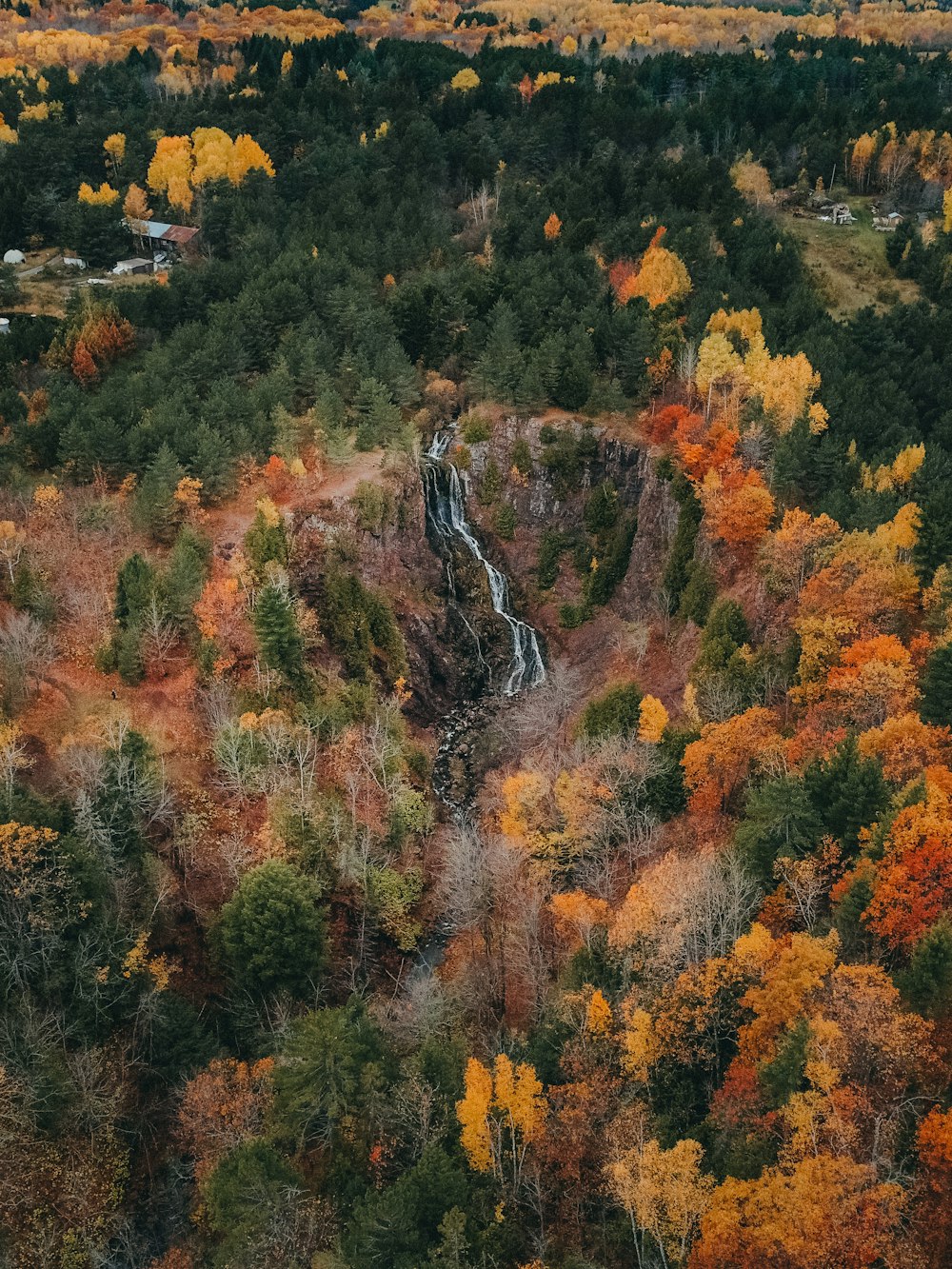 an aerial view of a waterfall surrounded by trees