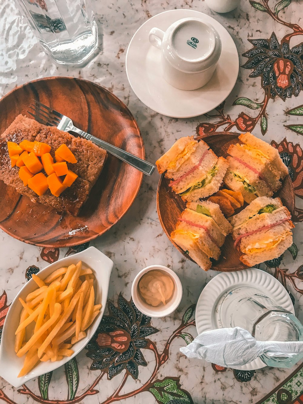 a table topped with plates of food and cups of coffee