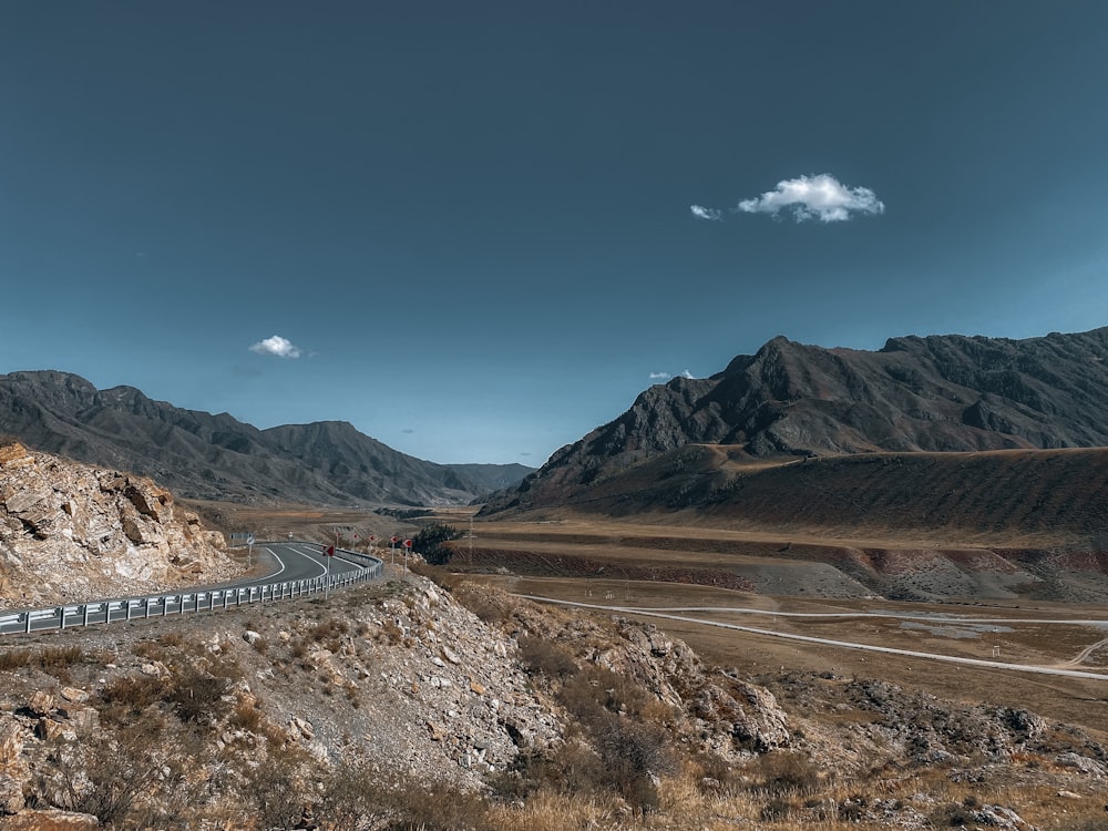 a long train traveling through a mountainous valley