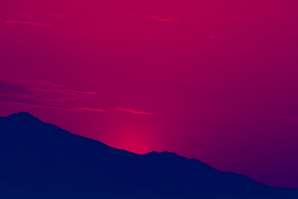 a red and blue sky with a plane in the foreground