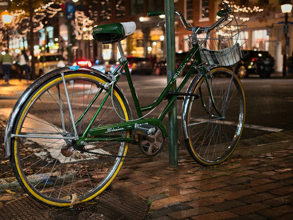 a green bike parked on the side of a street